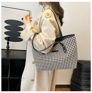 Side view of model wearing a black and white houndstooth tote bag in modern interior