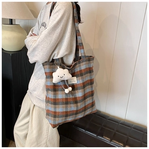 Detailed view of the large capacity wool plaid tote bag with cloud charm accessory