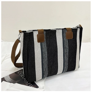 Close-up of a striped tote bag featuring black, white, and grey woven canvas textures