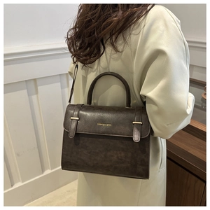 Détail d'un sac bandoulière gris anthracite rétro avec texture vintage et texte doré