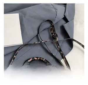 Detail of leopard print crossbody bag featuring golden hardware and round top handle
