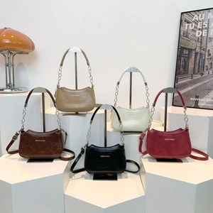 Chic crescent shoulder bags with chain straps in five colors on a geometric display