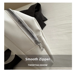 Detailed macro of smooth silver metal zipper on white pebble leather shoulder bag