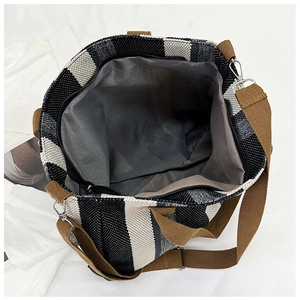 Overhead view showing spacious grey lining and zip closure of striped canvas tote bag