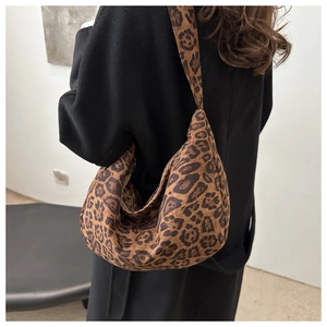 Close-up of leopard print oversized tote bag showing textured fabric and wide shoulder strap