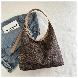 Détail du sac cabas léopard avec lanières marron assorti à une veste en jean