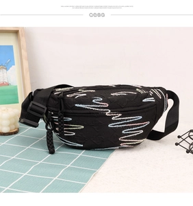 Close-up of black crossbody bag with colorful wavy embroidery and adjustable strap
