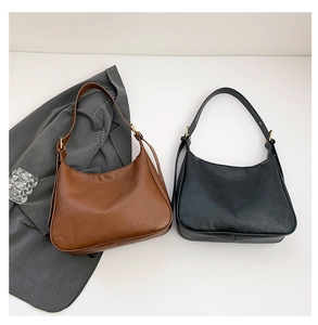 Detail of trendy hobo bags in brown and black with textured leather and gold hardware