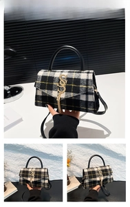 Detail view of black and white plaid wool purse with gold S pendant and leather strap