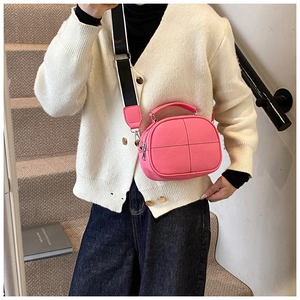 Detailed view of pink pebble leather crossbody bag featuring crossbody wide strap and silver hardware