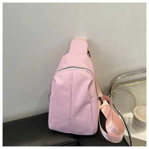 Close-up of pink PU leather chest bag with vertical pleats and adjustable strap