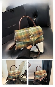 Detail of green plaid tweed handbag with leather handle and gold hardware in luxury setting