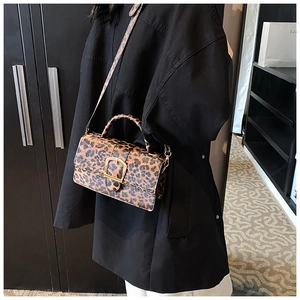 Detail of leopard print crossbody bag with gold buckle and adjustable strap