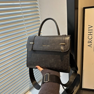 Minimalist black crossbody messenger bag with vintage texture and golden decorative buckle