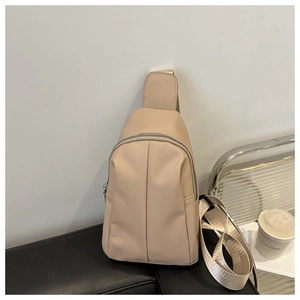 Detail of minimalist beige nylon crossbody chest bag with smooth metal zipper and thick strap