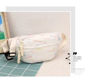 Close-up of white corduroy waist bag featuring colorful wave embroidery and zipper detail