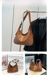 Detail of a brown pleated leather hobo tote bag with adjustable strap and gold buckle