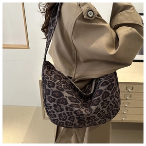 Detail of leopard print tote bag styled with a beige trench coat for a trendy commute look