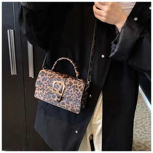 Detail showing vintage leopard print crossbody bag with a large gold metallic buckle closure