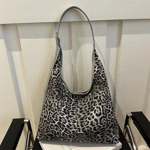 Leopard print large capacity shoulder bag for women with adjustable strap on white book