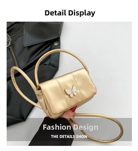 Détail du mini sac doré avec boucle papillon blanche élégante et poignée en cuir chic