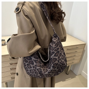 Detailed side view of a large leopard print tote bag paired with a beige trench coat