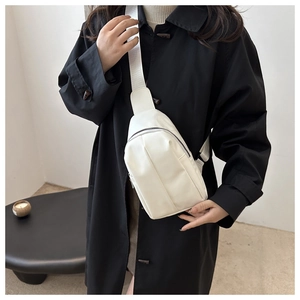 Minimalist white PU leather crossbody chest bag with adjustable strap on black coat