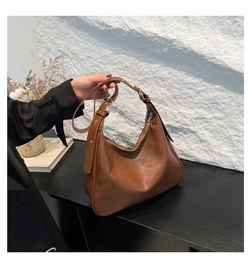 Detail of vintage caramel tote bag with soft leather texture and bronze metal buckle
