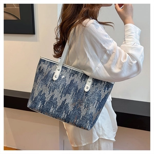 Close-up of blue denim sequin tote bag showing silver patterns and leather straps