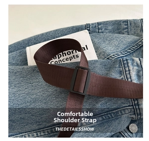 Detail of adjustable brown nylon shoulder strap with a sturdy black plastic buckle