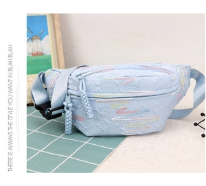 Detail of light blue waist bag showing colorful wave embroidery and dual zipper closure