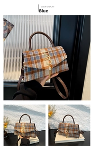 Detail of blue and orange plaid handbag with golden tassel and leather handle