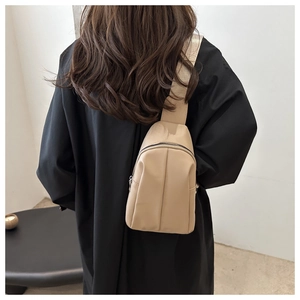 Beige nylon crossbody bag with wide strap shown on model back for casual outdoor style