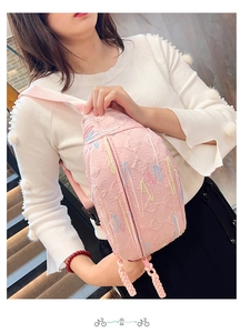 Detail of pink corduroy crossbody bag with wavy embroidery and textured letter patterns