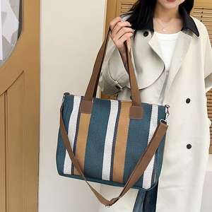 Striped canvas tote bag with large capacity shown in crossbody style on model