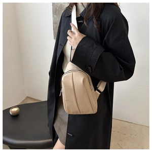 Macro detail of beige PU leather sling bag with vertical stitching and dual zippers