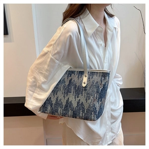 Blue denim tote bag with silver sequins and metallic straps worn by model