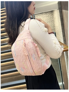 Detail of pink corduroy crossbody bag with rainbow stitching and embossed LL pattern texture