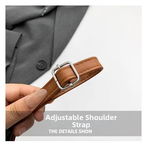 Detail of brown faux leather bag with adjustable silver buckle strap and neat stitching