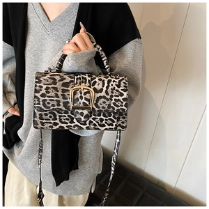 Detail of trendy leopard print crossbody bag with golden horseshoe buckle and strap