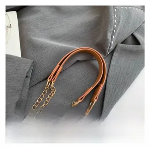 Detail view of a luxury brown leather and gold metal chain shoulder strap for handbags
