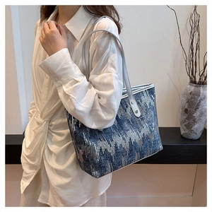Close-up of stylish tote bag with silver streamlines and soft faux leather handles
