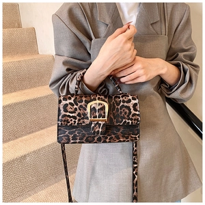 Close-up of leopard print crossbody bag with gold horseshoe buckle and flap closure