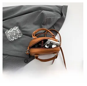 Internal capacity of the caramel bowling bag showing phone and lipstick storage
