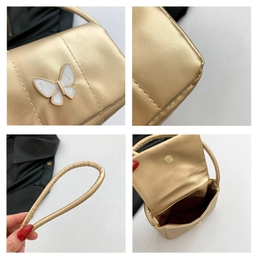 Détails du sac à main doré avec boucle papillon blanche et doublure intérieure rouge vin