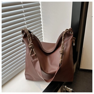 Close-up of coffee brown tote bag with thick rope straps and matte soft leather texture