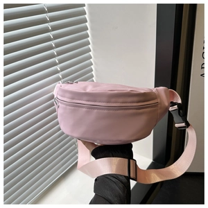 Detail of pink canvas belt bag showing silver zipper and adjustable buckle strap