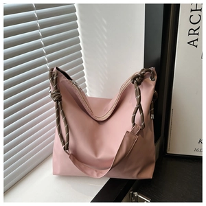 Detail of pink large capacity tote bag with chunky rope handle and knot decoration
