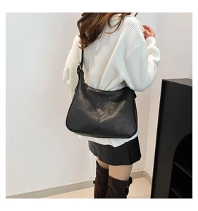 Detail view of high-quality matte black leather texture on a stylish women's tote bag