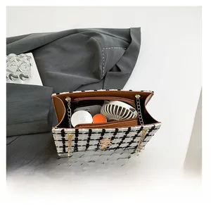 Interior view of checkered tweed tote bag showing storage capacity for daily essentials
